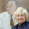 Dame Vivien Duffield stands in front of a portrait of her father, Sir Charles Clore.